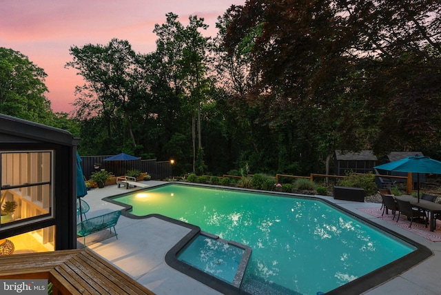 4304 Starview Ct, Glen Arm, MD 21057 - pool at dusk featuring a patio area, a fenced backyard, a pool with connected hot tub, and outdoor dining area