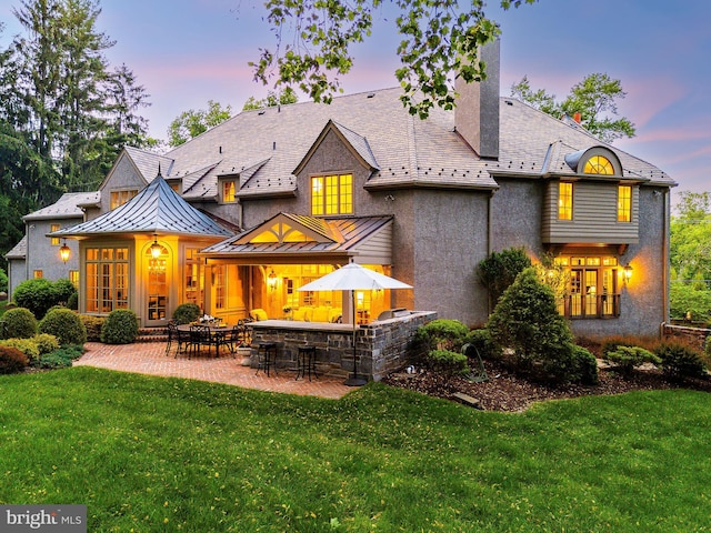 1412 Mount Pleasant Rd, Villanova, PA 19085 - back of house with a standing seam roof, a lawn, a patio, and stucco siding