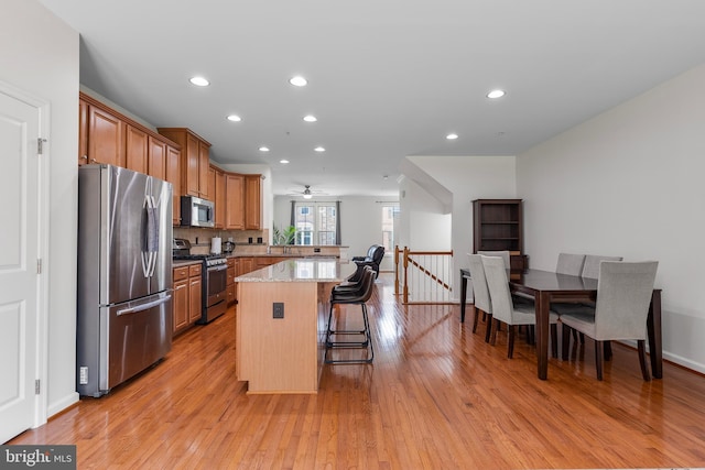 9161 Landon House Ln, Frederick, MD 21704 - kitchen with stainless steel appliances, a kitchen breakfast bar, a peninsula, light wood-style flooring, and recessed lighting