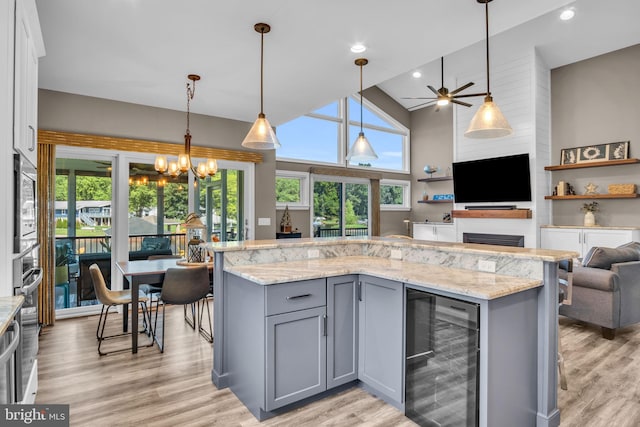 61 Bragg Dr, East Berlin, PA 17316 - kitchen with beverage cooler, gray cabinets, open floor plan, light wood-style flooring, and light stone counters