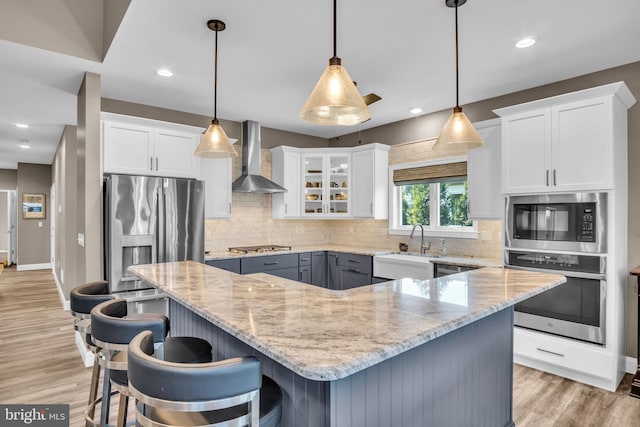 61 Bragg Dr, East Berlin, PA 17316 - kitchen with appliances with stainless steel finishes, wall chimney exhaust hood, white cabinets, decorative backsplash, and light stone countertops