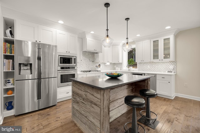1217 Carrollsburg Pl SW, Washington, DC 20024 - kitchen with appliances with stainless steel finishes, backsplash, light wood-style floors, white cabinetry, and recessed lighting