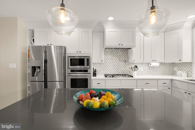 1217 Carrollsburg Pl SW, Washington, DC 20024 - kitchen featuring stainless steel appliances, white cabinetry, decorative backsplash, recessed lighting, and hanging light fixtures