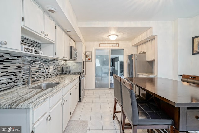 3725 King Ave, Pennsauken, NJ 08110 - kitchen with stainless steel appliances, backsplash, white cabinetry, and light tile patterned flooring
