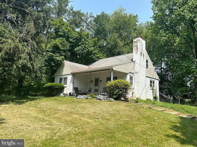 3861 Mill Rd, Collegeville, PA 19426 - rear view of property with a porch, a lawn, a chimney, and stucco siding
