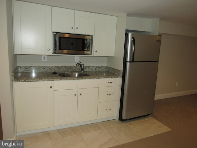 3528 14th St N, Arlington, VA 22201 - kitchen featuring appliances with stainless steel finishes, a sink, white cabinets, stone counters, and baseboards