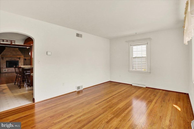 217 E Chestnut St, Cleona, PA 17042 - unfurnished room with arched walkways, wood finished floors, baseboards, and a fireplace