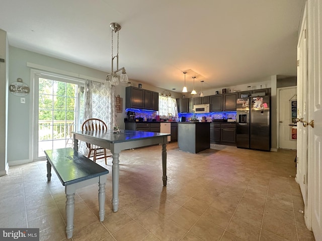127 Miles Cir, Hurlock, MD 21643 - kitchen with stainless steel fridge with ice dispenser, white microwave, dark countertops, a center island, and decorative backsplash
