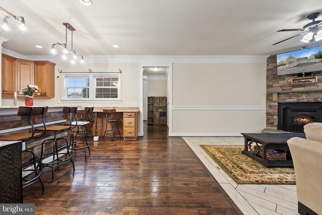 1257 N Fairfax Blvd, Ranson, WV 25438 - dining space featuring crown molding, ceiling fan, dark wood-style floors, a stone fireplace, and recessed lighting