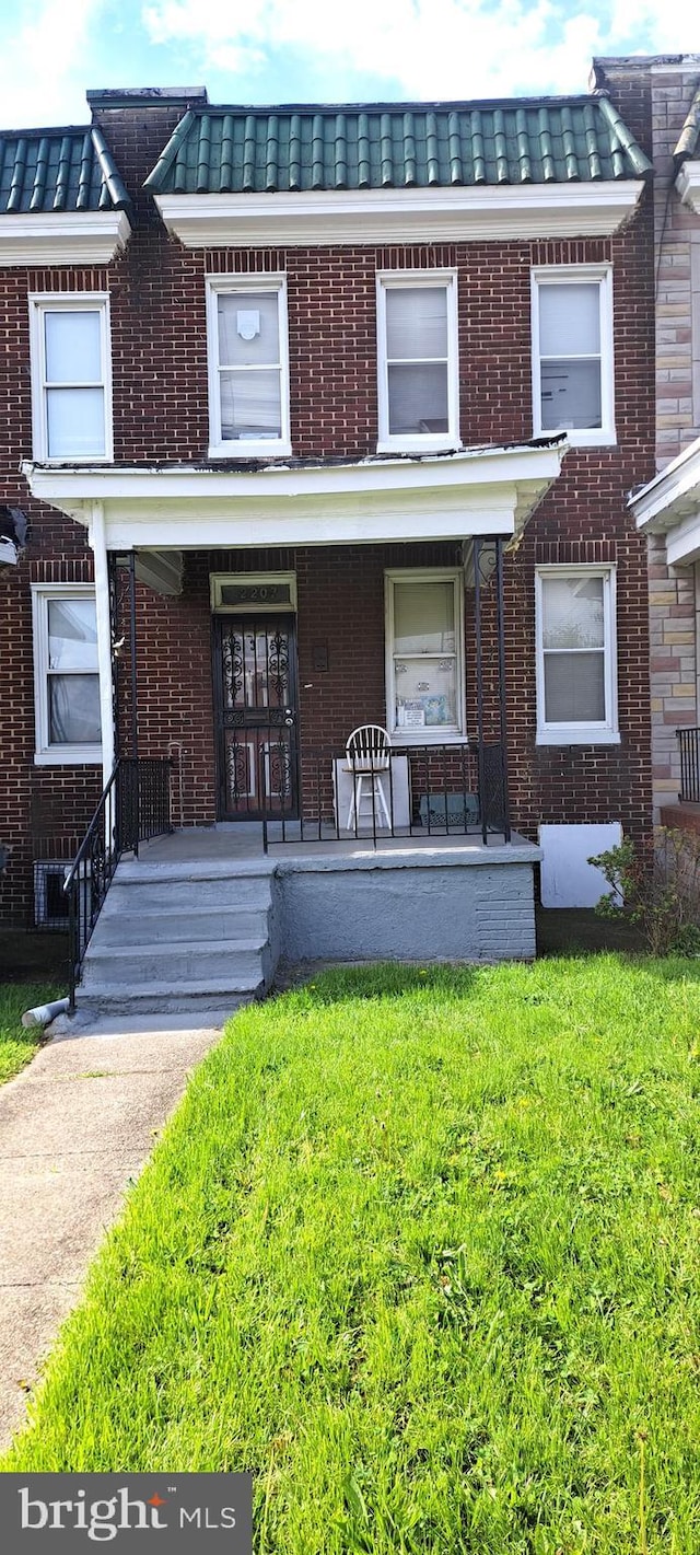 2207 W Lafayette Ave, Baltimore, MD 21216 - multi unit property with brick siding, a porch, and a front lawn