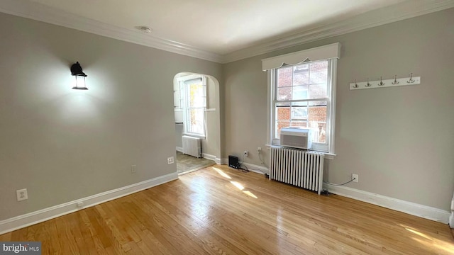 721 Erie Ave Unit 721-2, Takoma Park, MD 20912 - spare room with radiator heating unit, arched walkways, crown molding, and wood finished floors