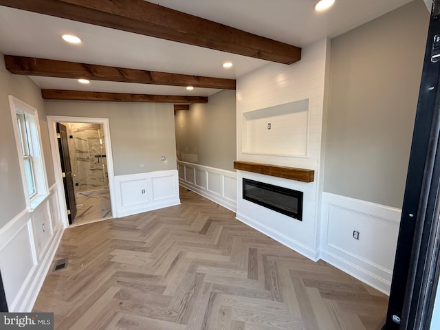 422 11th St SE, Washington, DC 20003 - unfurnished living room with a decorative wall, a wainscoted wall, beamed ceiling, recessed lighting, and a glass covered fireplace