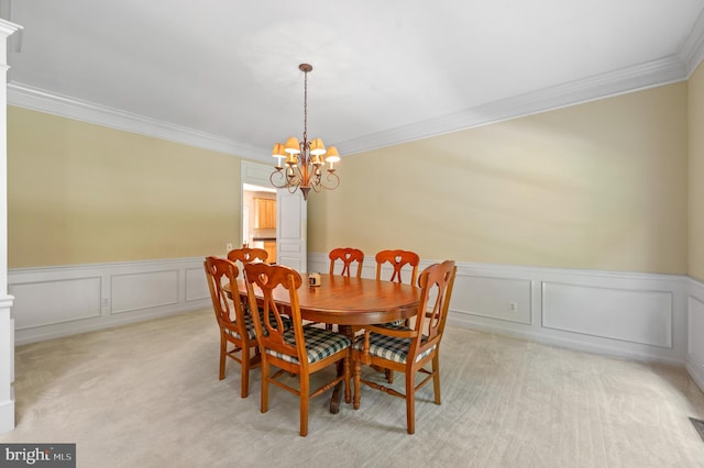 859 Empress Rd, West Chester, PA 19382 - dining area with crown molding, light carpet, a chandelier, a decorative wall, and wainscoting