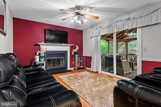 10462 Brackets Ford Cir, Manassas, VA 20110 - living room with wood finished floors, a fireplace with flush hearth, a ceiling fan, and a textured ceiling