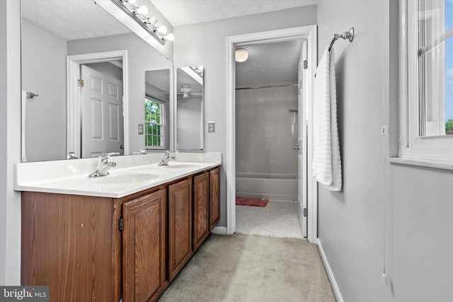 10462 Brackets Ford Cir, Manassas, VA 20110 - bathroom with double vanity, a textured ceiling, a ceiling fan,  shower combination, and baseboards