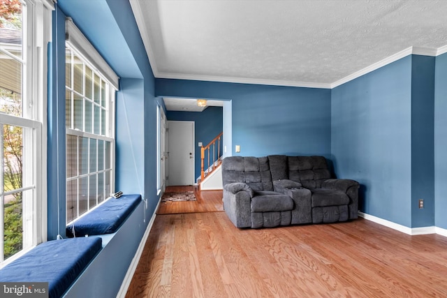 10462 Brackets Ford Cir, Manassas, VA 20110 - living room with wood finished floors, baseboards, stairway, a textured ceiling, and crown molding