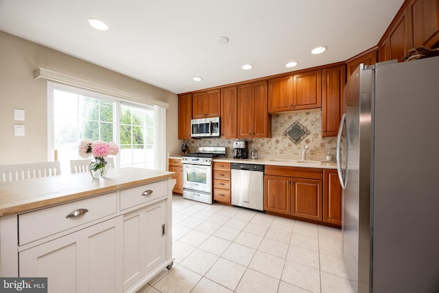 32 Granite Ln Unit 8, Chester Springs, PA 19425 - kitchen featuring appliances with stainless steel finishes, light countertops, backsplash, light tile patterned floors, and brown cabinets