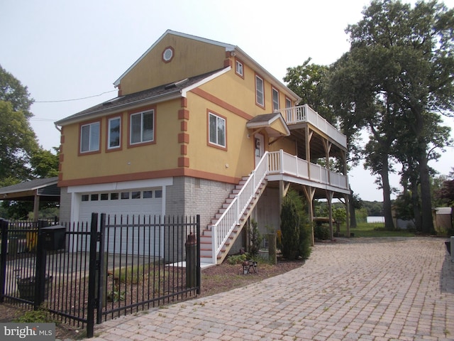 2115 Lake Dr, Pasadena, MD 21122 - view of front of property featuring a garage, decorative driveway, stairs, brick siding, and stucco siding