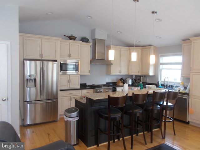 2115 Lake Dr, Pasadena, MD 21122 - kitchen with stainless steel appliances, wall chimney exhaust hood, cream cabinets, a kitchen island, and light wood-style flooring