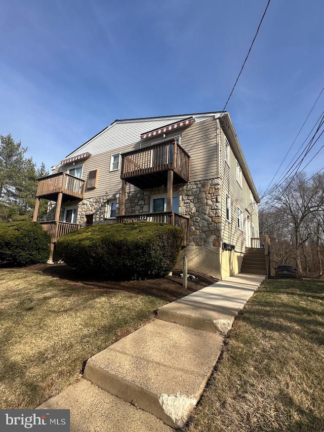 713A-2 Willow St # A-2, Lansdale, PA 19446 - view of front of house featuring stone siding, a balcony, and a front yard