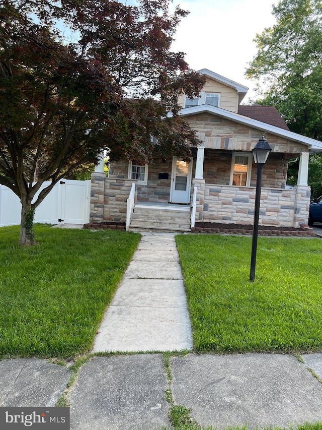 818 Warwick Rd, Baltimore, MD 21229 - view of front facade featuring stone siding, covered porch, and a gate