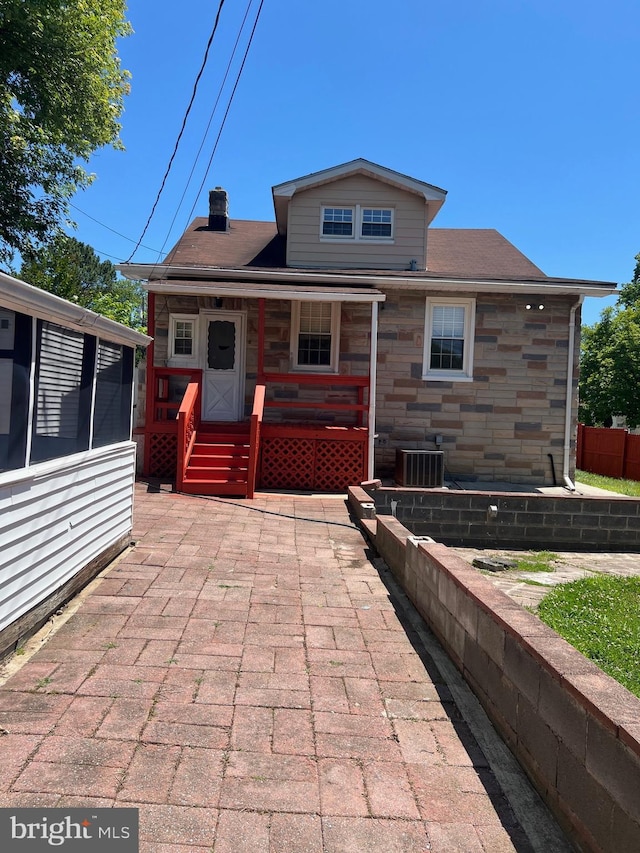 818 Warwick Rd, Baltimore, MD 21229 - back of house featuring stone siding, cooling unit, and a chimney