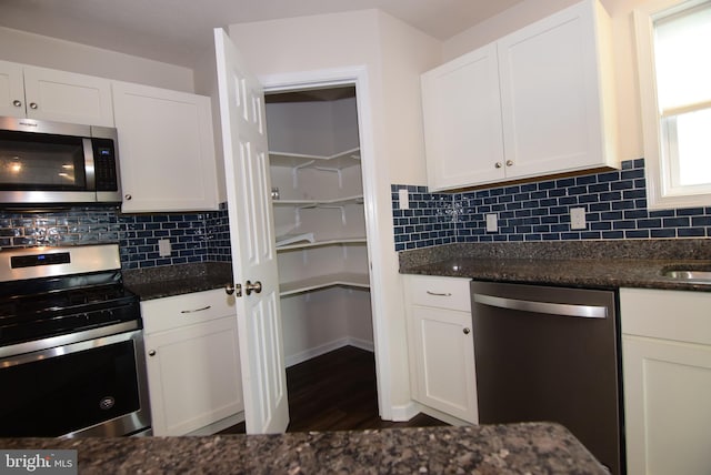 119 Shady Hollow Dr, Pleasant Gap, PA 16823 - kitchen featuring stainless steel appliances, white cabinetry, dark stone countertops, backsplash, and dark wood-style flooring