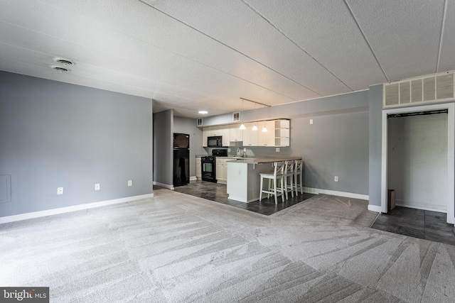 2624 Wagon Dr Unit 307, Alexandria, VA 22303 - kitchen featuring black appliances, open floor plan, carpet flooring, and a breakfast bar area