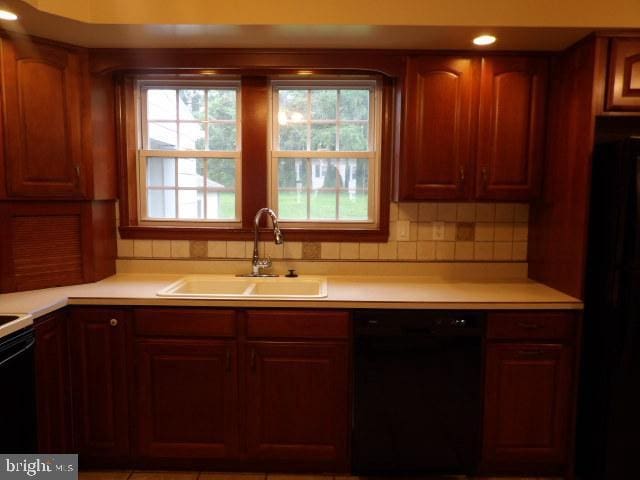 612 S Thomas St, Bedford, PA 15522 - kitchen with black dishwasher, a sink, light countertops, and decorative backsplash