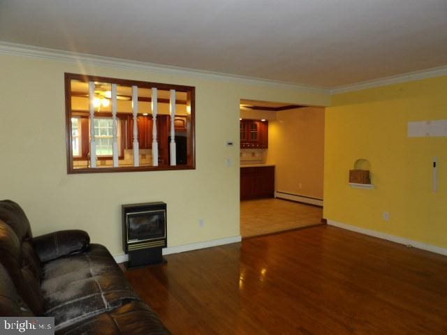 612 S Thomas St, Bedford, PA 15522 - living area featuring baseboard heating, wood finished floors, ornamental molding, baseboards, and a glass covered fireplace