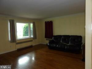 612 S Thomas St, Bedford, PA 15522 - living area with radiator heating unit and wood finished floors