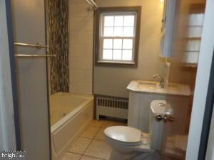 612 S Thomas St, Bedford, PA 15522 - full bathroom featuring radiator heating unit, toilet, vanity, shower / bathtub combination, and tile patterned floors
