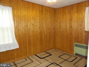 612 S Thomas St, Bedford, PA 15522 - empty room featuring radiator, a sauna / steam room, and wood walls
