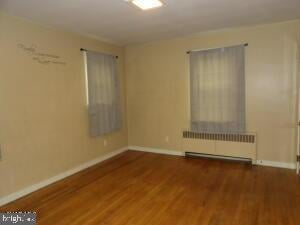 612 S Thomas St, Bedford, PA 15522 - spare room featuring radiator, baseboards, and wood finished floors
