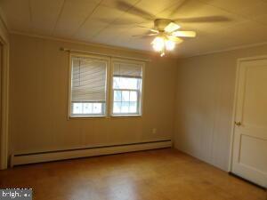 612 S Thomas St, Bedford, PA 15522 - spare room featuring a baseboard heating unit, a ceiling fan, and crown molding