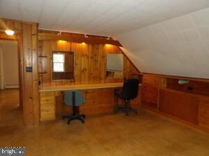 612 S Thomas St, Bedford, PA 15522 - home office with vaulted ceiling, built in desk, a baseboard radiator, and wood walls