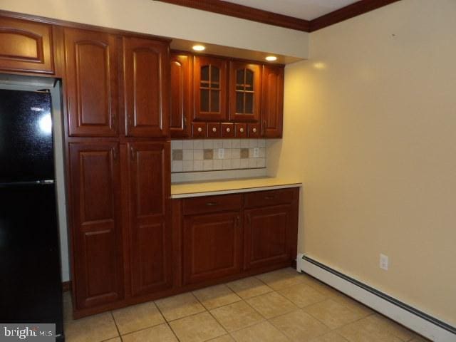 612 S Thomas St, Bedford, PA 15522 - kitchen with freestanding refrigerator, a baseboard heating unit, backsplash, light countertops, and light tile patterned flooring