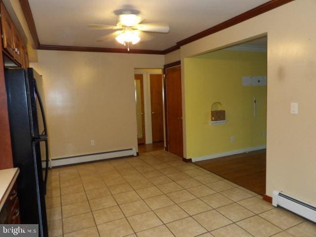 612 S Thomas St, Bedford, PA 15522 - empty room with a baseboard heating unit, a ceiling fan, crown molding, and light tile patterned floors