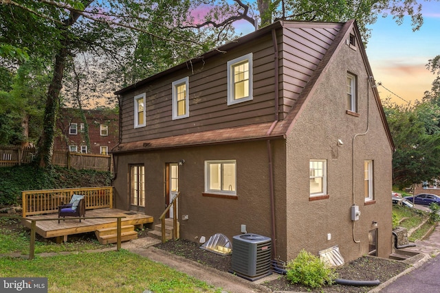 514 Silver Spring Ave, Silver Spring, MD 20910 - back of house at dusk featuring central AC unit, stucco siding, and a wooden deck
