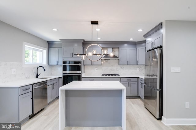 5002 Chalgrove Ave, Baltimore, MD 21215 - kitchen with stainless steel appliances, gray cabinetry, a sink, wall chimney exhaust hood, and light wood-style flooring