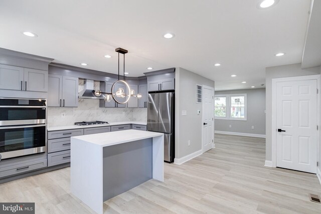 5002 Chalgrove Ave, Baltimore, MD 21215 - kitchen featuring stainless steel appliances, gray cabinets, wall chimney range hood, light countertops, and decorative backsplash