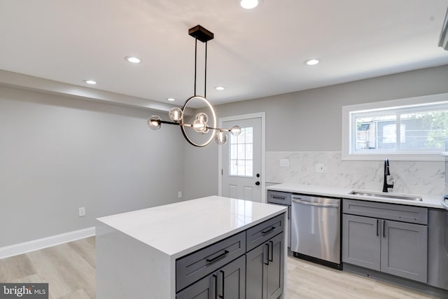 5002 Chalgrove Ave, Baltimore, MD 21215 - kitchen with stainless steel dishwasher, a sink, gray cabinets, light wood-style flooring, and plenty of natural light