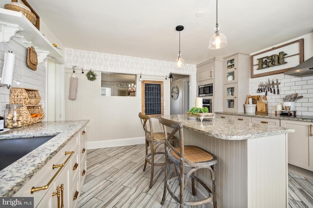 389 Cypress St, Millington, MD 21651 - kitchen featuring decorative backsplash, stainless steel appliances, a breakfast bar area, wood finish floors, and baseboards
