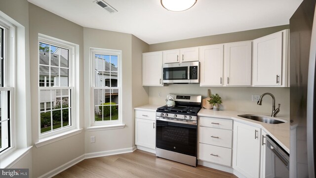 1703 Hopkins Ct, Southampton, PA 18966 - kitchen with stainless steel appliances, light wood-type flooring, white cabinetry, and light countertops