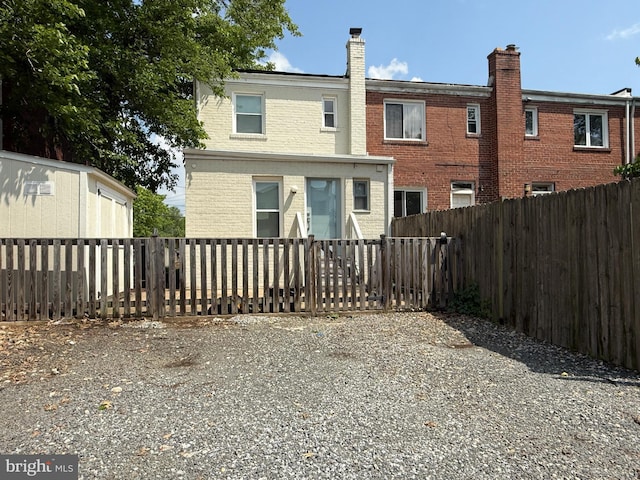 11 Clifford Ave, Alexandria, VA 22305 - back of house with a fenced backyard, brick siding, and a chimney
