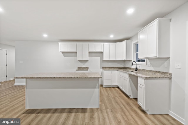 183 Silage Ln, Berkeley Springs, WV 25411 - kitchen featuring a sink, light wood-type flooring, a center island, baseboards, and white cabinetry