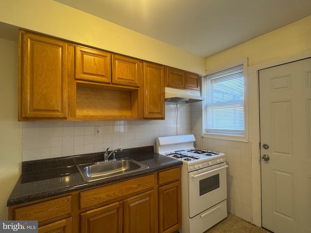 331 Garden Ave, Camden, NJ 08105 - kitchen featuring under cabinet range hood, gas range gas stove, a sink, brown cabinetry, and tasteful backsplash