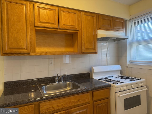 331 Garden Ave, Camden, NJ 08105 - kitchen featuring white gas range, under cabinet range hood, a sink, and brown cabinetry
