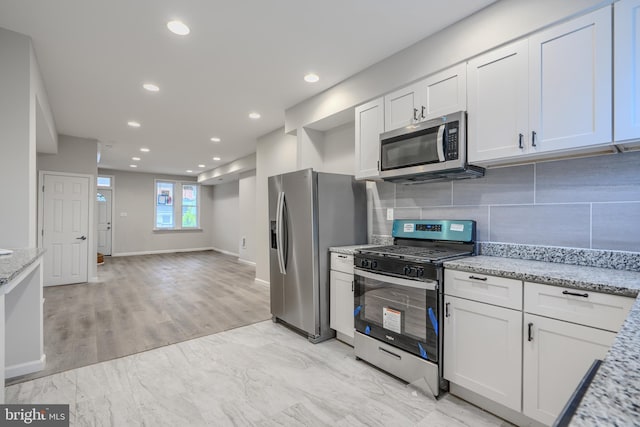 1229 N Potomac St, Baltimore, MD 21213 - kitchen featuring stainless steel appliances, white cabinetry, light stone countertops, backsplash, and recessed lighting
