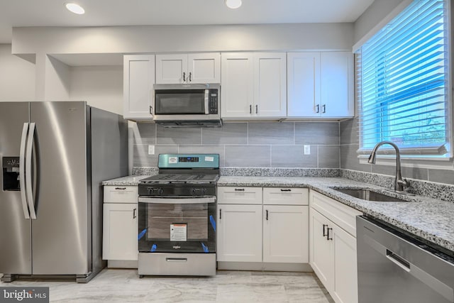 1229 N Potomac St, Baltimore, MD 21213 - kitchen featuring stainless steel appliances, a sink, white cabinets, light stone countertops, and recessed lighting